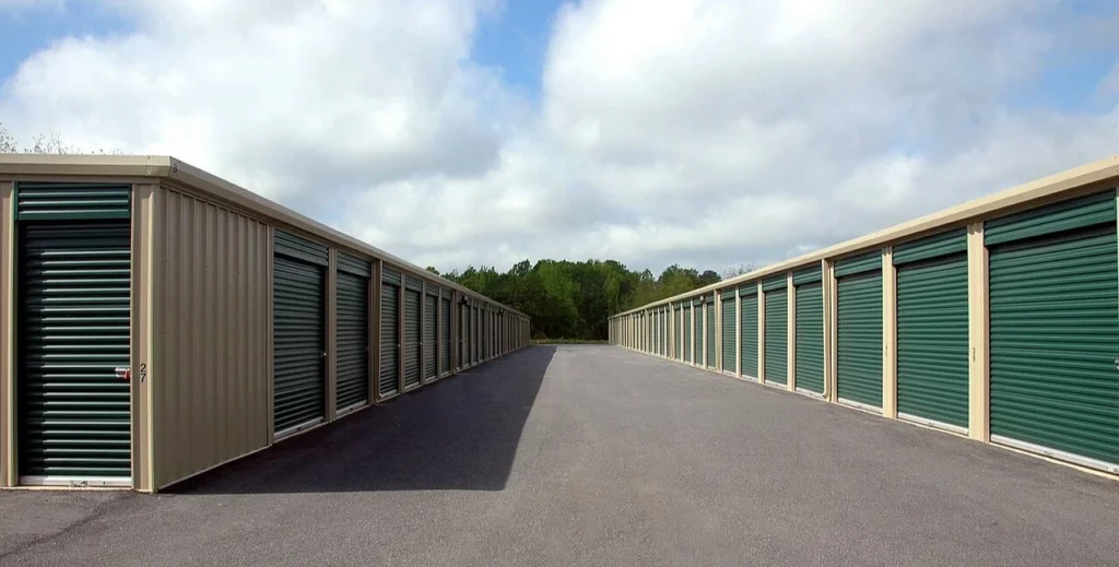 A row of storage units with green doors