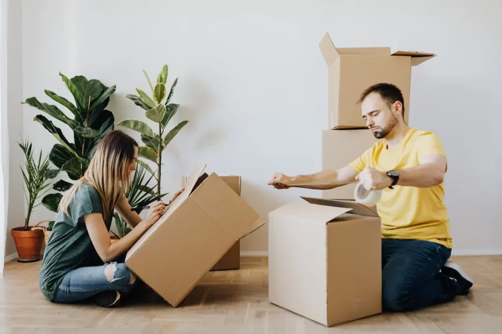 A man and a woman dividing their belongings into cardboard boxes